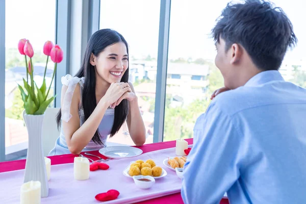 バレンタインデーのコンセプト 幸せなアジアの若い甘いカップルは レストランの背景にバラの花束でランチをロマンチックにしています — ストック写真