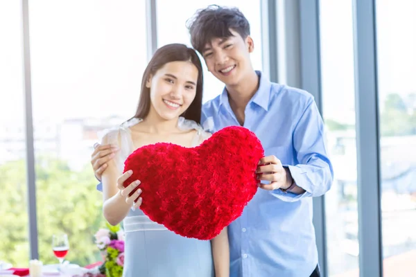 バレンタインデーのコンセプト アジアの若い幸せな甘いカップルの愛の赤いハート型の枕を保持昼食後レストランの背景では 愛の物語のカップル — ストック写真