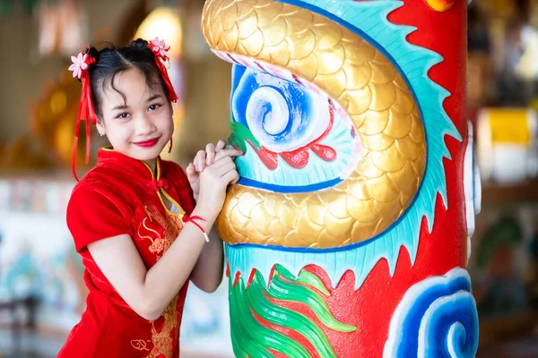 肖像画の美しい笑顔かわいいアジアの女の子は中国の神社で中国の旧正月の祭りのために赤い伝統的な中国のChongsam装飾を着て — ストック写真