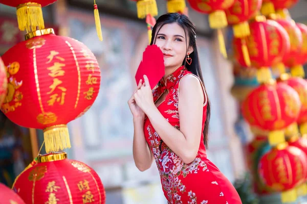 手に赤い封筒を持っている中国の伝統的な中国のChongsam装飾を身に着けているアジアの女性とそれに書かれた中国語のテキストの祝福と提灯は中国の旧正月のための幸運祝福です — ストック写真
