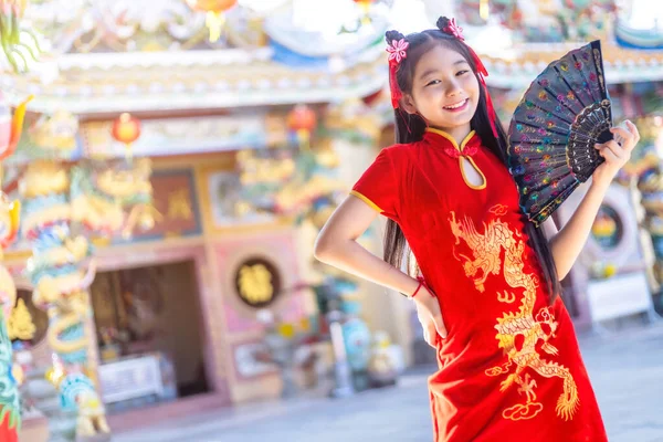 肖像画の美しい笑顔かわいいアジアの女の子は 中国の神社で中国の旧正月の祭りのために赤の伝統的な中国のChongsam装飾を身に着けていると開催 — ストック写真
