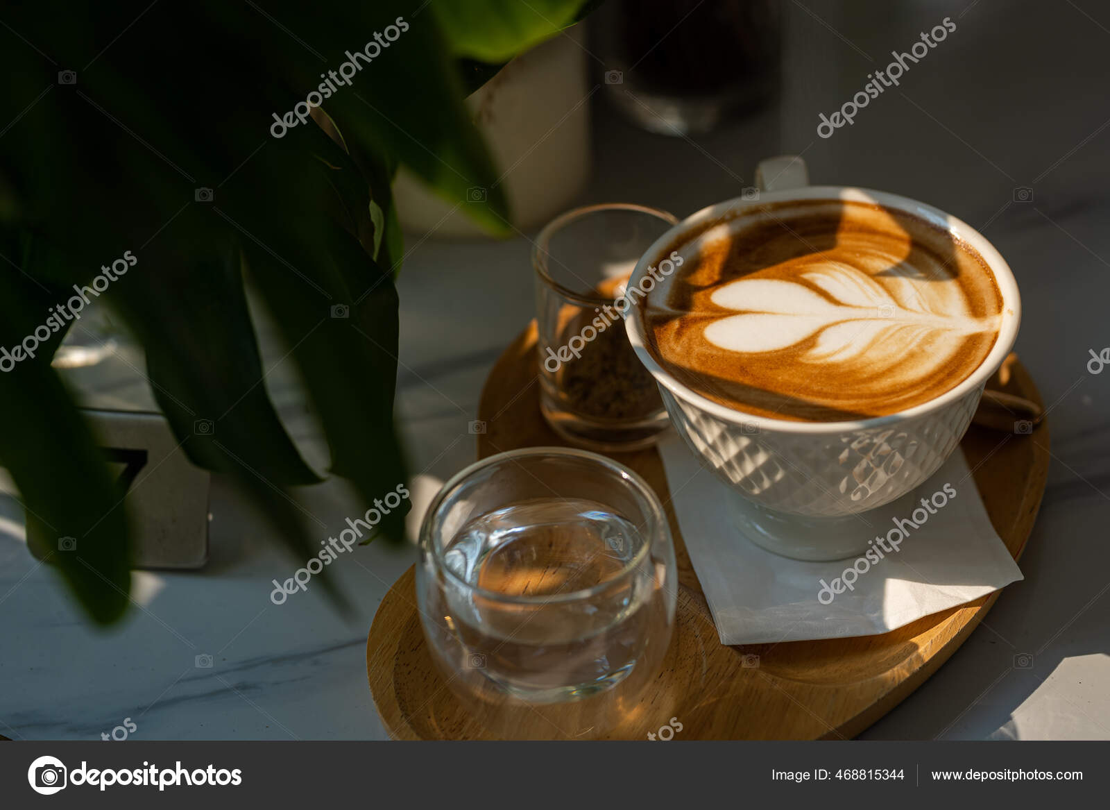 Hot coffee latte with latte art milk foam in cup mug on black wood desk on  top view. As breakfast In a coffee shop at the cafe,during business work  concept Stock Photo