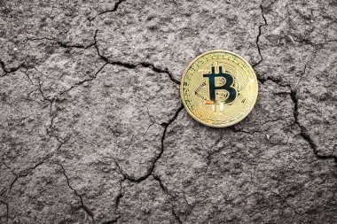 Kuru çatlamış zemin üzerinde Altın Bitcoin madeni para. Mali Kriz Konsepti Bitcoin Kripto Para Birimi.