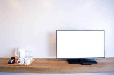 Televizyon ve televizyonun başında boş beyaz ekran ve kahve makinesi vardı. Alüminyum elektrikli su ısıtıcısı, temiz beyaz bardak, otel odasındaki tuğla duvarda beyaz şeker.