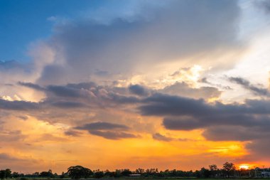 Alacakaranlık mavisi parlak ve turuncu sarı dramatik günbatımı gökyüzü kırsal ya da plaj renkli bulutlu hava arkaplanlı.