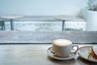 Sütlü sütlü sütlü sütlü sütlü sıcak kahve ve ahşap masanın üstünde ev yapımı çikolatalı kurabiyeler. Kafedeki bir kafede kahvaltı olarak, iş sırasında..