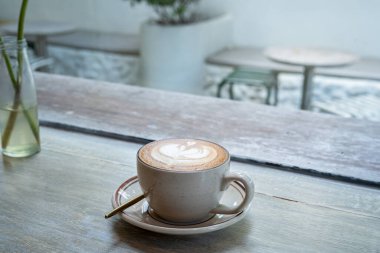 Sütlü sütlü sütlü sütlü sıcak kahve fincanı ahşap masanın üstünde. Kafedeki bir kafede kahvaltı olarak, iş konsepti sırasında, klasik tarzda.