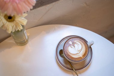 Sütlü sütlü sütlü sütlü sıcak kahve fincanı ahşap masanın üstünde. Kafedeki bir kafede kahvaltı olarak, iş konsepti sırasında, klasik tarzda.