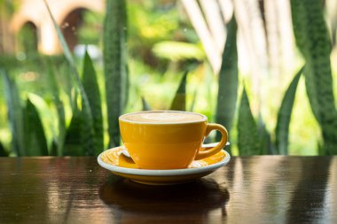 Sütlü sütlü sütlü sütlü sıcak kahve fincanı ahşap masanın üstünde. Kafedeki bir kafede kahvaltı olarak, iş konsepti sırasında, klasik tarzda.