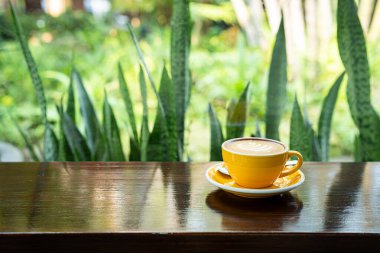 Sütlü sütlü sütlü sütlü sıcak kahve fincanı ahşap masanın üstünde. Kafedeki bir kafede kahvaltı olarak, iş konsepti sırasında, klasik tarzda.
