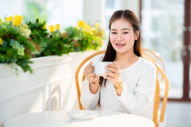Gülümseyen Asyalı güzel bir kadının portresi kafenin arka planında rahatlıyor, İş Hayatı yaz tatili konsepti.