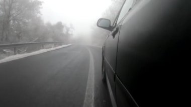 Araç kışın manzaralı dağ yolundan geçiyor.