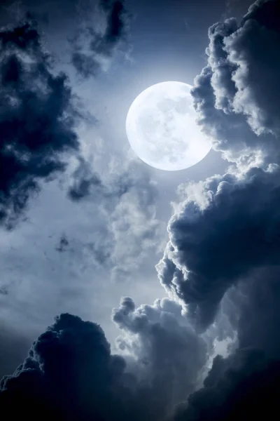 This dramatic photo illustration of a nighttime scene with brightly lit clouds and large, full, Blue Moon would make a great background for many uses. — Stock Photo, Image