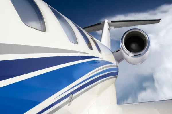 This photo illustration of a business jet is created from a unique in-flgiht perspective, from outside the aircraft, with slight motion blur, beautiful clouds and deep blue sky — Φωτογραφία Αρχείου