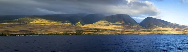 This beautiful sunset view of the West Coast of Maui Hawaii shows the tall mountains, valleys and shield volcano making up one third of this island. This view taken from a sunset dinner cruise can be what you'll expect on vacation here. — Stock Photo, Image