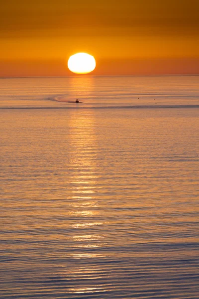 Este barco de pesca se dirige a casa de la pesca en frente de una hermosa puesta de sol en Clearwater Beach, Florida en el Golfo de México . Fotos de stock libres de derechos