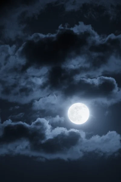 Esta dramática ilustración fotográfica de una escena nocturna con nubes brillantemente iluminadas y una Luna Azul grande y llena sería un gran fondo para muchos usos . Fotos de stock libres de derechos
