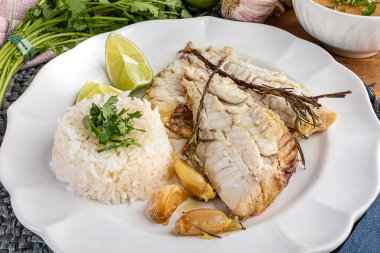 Bitki, sarımsak, tuz ve limonla tatlandırılmış kızarmış kırmızı balık. Yanında beyaz pirinç ve lapa..