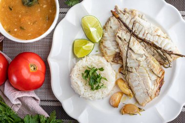 Bitki, sarımsak, tuz ve limonla tatlandırılmış kızarmış kırmızı balık. Yanında beyaz pirinç ve lapa..