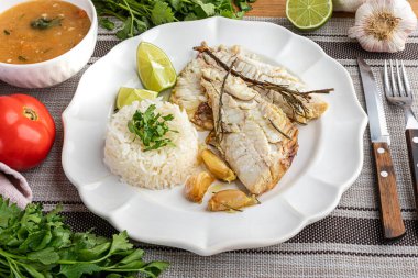 Bitki, sarımsak, tuz ve limonla tatlandırılmış kızarmış kırmızı balık. Yanında beyaz pirinç ve lapa..