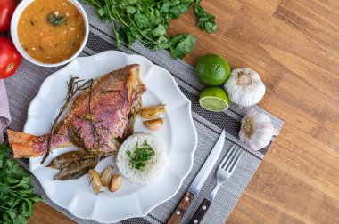 Bitki, sarımsak, tuz ve limonla tatlandırılmış kızarmış kırmızı balık. Yanında beyaz pirinç ve lapa..