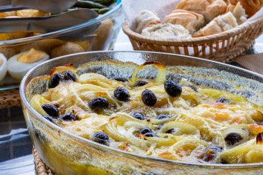 Zeytinyağında pişirilmiş morina filetosu, patates, brokoli, haşlanmış yumurta ve siyah zeytin. Portekiz 'in tipik yemeği.