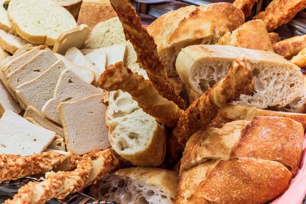 Basket of bread with different types of cheese on the table.