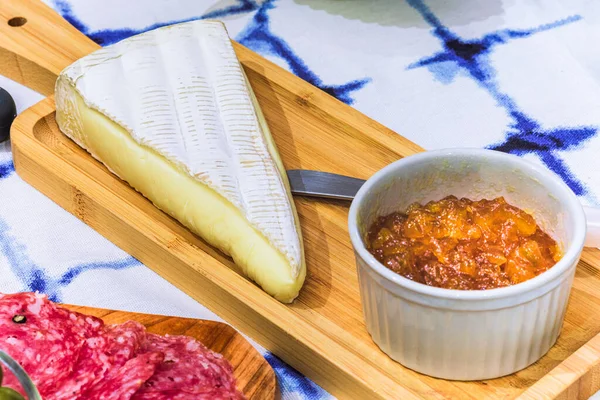 Brie cheese with apricot and snacks on the table for tasting and holiday scenery.