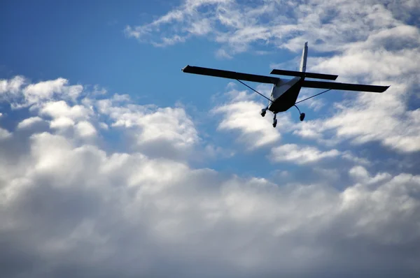 Pequeño avión volando en el cielo nublado —  Fotos de Stock