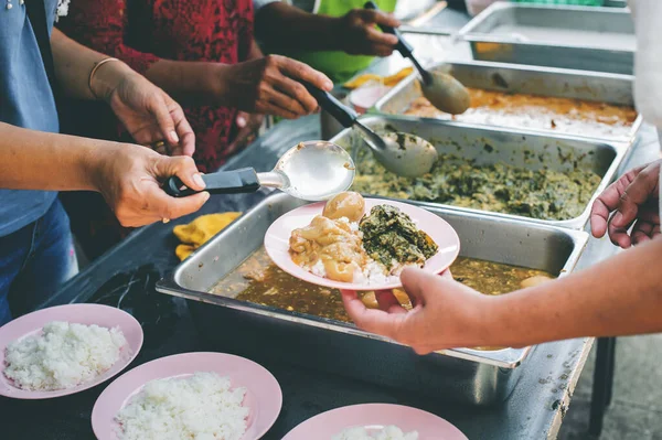 Volunteers giving food to poor people: The concept of food sharing Help solve Hunger for the homeless
