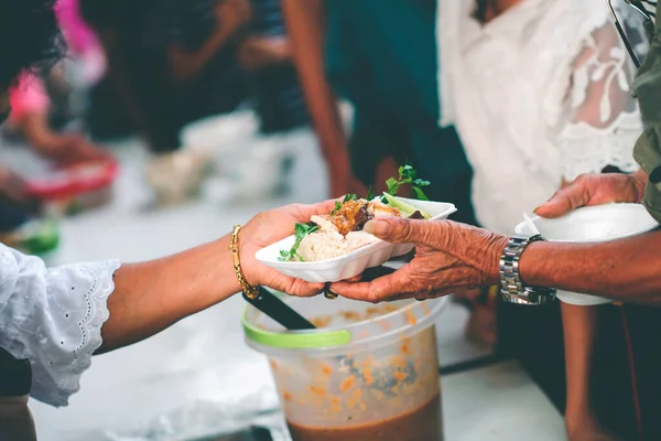 Volunteers giving food to poor people: The concept of food sharing Help solve Hunger for the homeless