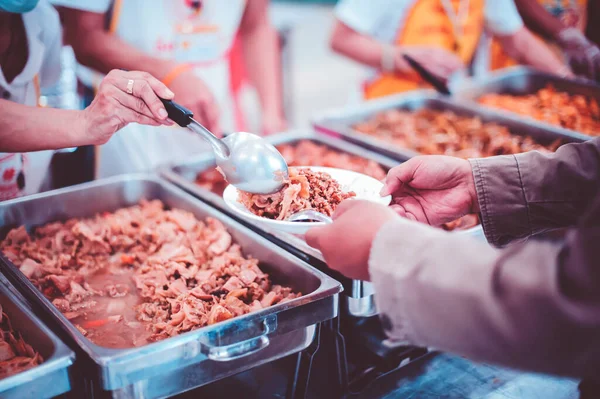 concept of charity food for the poor: Volunteers give food to the poor