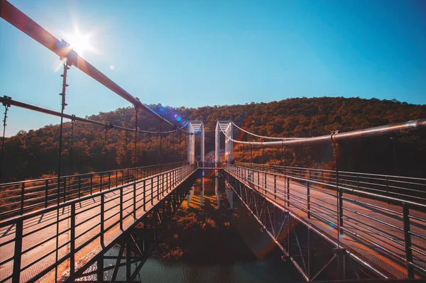 Αναστολή Γέφυρα Κατά Μήκος Του Ποταμού Συνδέει Βουνά Φακό Φωτοβολίδα — Φωτογραφία Αρχείου