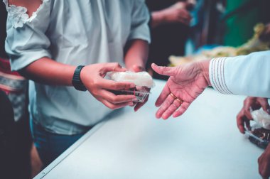 Aç evsizler Tayland 'da bir gönüllüden yiyecek alıyor..