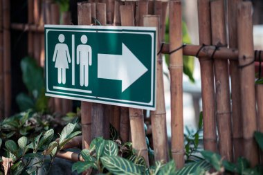 Tuvaletlere giden yolu gösteren tabela bahçedeki bambu rıhtımına yerleştirildi..