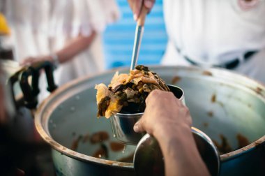 Açların elleri, gönüllülerin ellerinden yiyecek, evsizler için yiyecek yardımı alıyor.