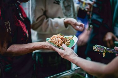 Açların elleri donörden yiyecek istiyor.