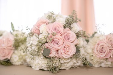 Beyaz gül buketi cam kavanozda beyaz dantelli ve mor örtülü masa.