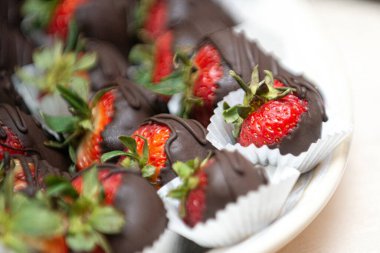 Tatlı çikolata kaplı, çöl barındaki beyaz tabakta duran merdiven meyveleri.