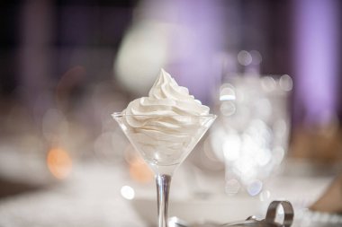 Zarif yemek masasında çırpılmış tereyağıyla dolu martini bardağı.