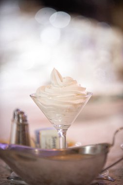 Zarif yemek masasında çırpılmış tereyağıyla dolu martini bardağı.