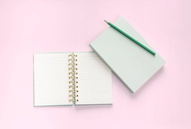düz yeşil renkli kitap ve kırtasiye pembe pastel zemin arka planı
