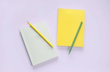 düz serili kitap kırtasiyesi ve mor arka planda kalem