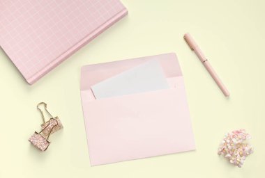 düz pembe kitap kırtasiyesi ve sarı arka planda mektup