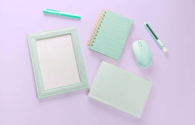 düz yeşil renkli kırtasiye malzemesi mor pastel zeminde.