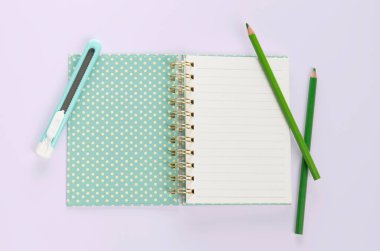 düz serili kitap kırtasiyesi ve mor arka plan üzerindeki kalem