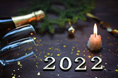 Yeni yıl 2022. Ahşap arka planda gözlüklü şampanya..