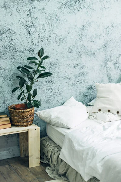 Çatı katı tarzı iç mekan. Yatak ve gri duvar.