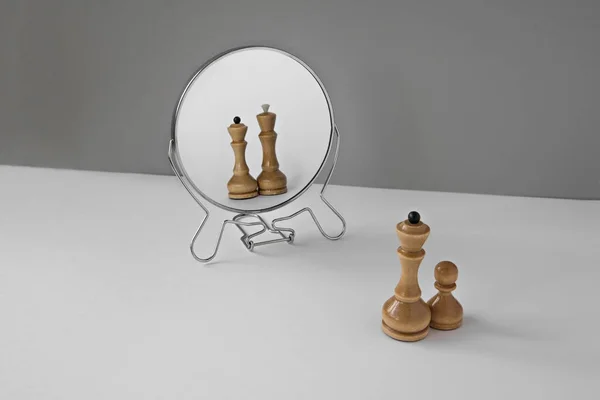 Шахові фігури королева і пішак дивляться у дзеркало. Мінімалістична концепція нарцисичного розладу особистості . — стокове фото