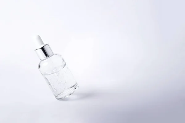 Flaska ansikte serum leviterar på en vit bakgrund. — Stockfoto